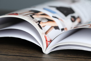 Photo of One open magazine on wooden table, closeup