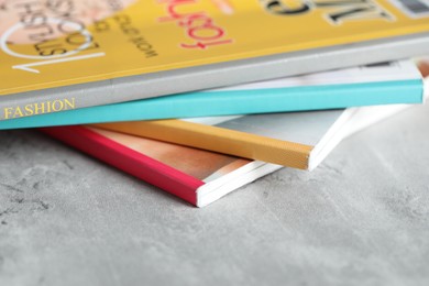 Photo of Stack of different magazines on grey table, closeup