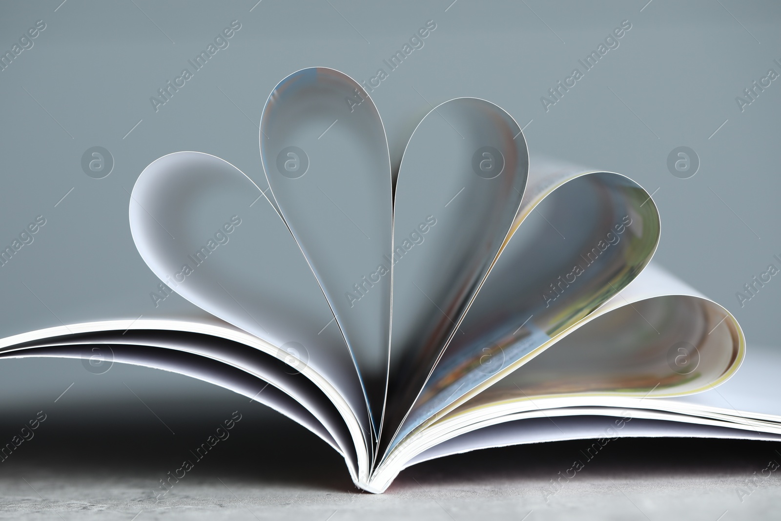 One open magazine on grey table, closeup Photo of One open magazine on grey table, closeup