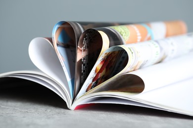 Photo of One open magazine on grey table, closeup