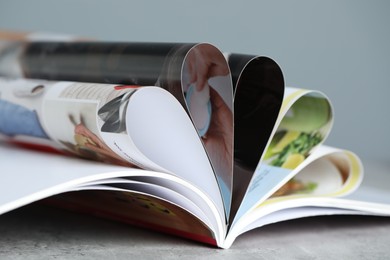 Photo of One open magazine on grey table, closeup