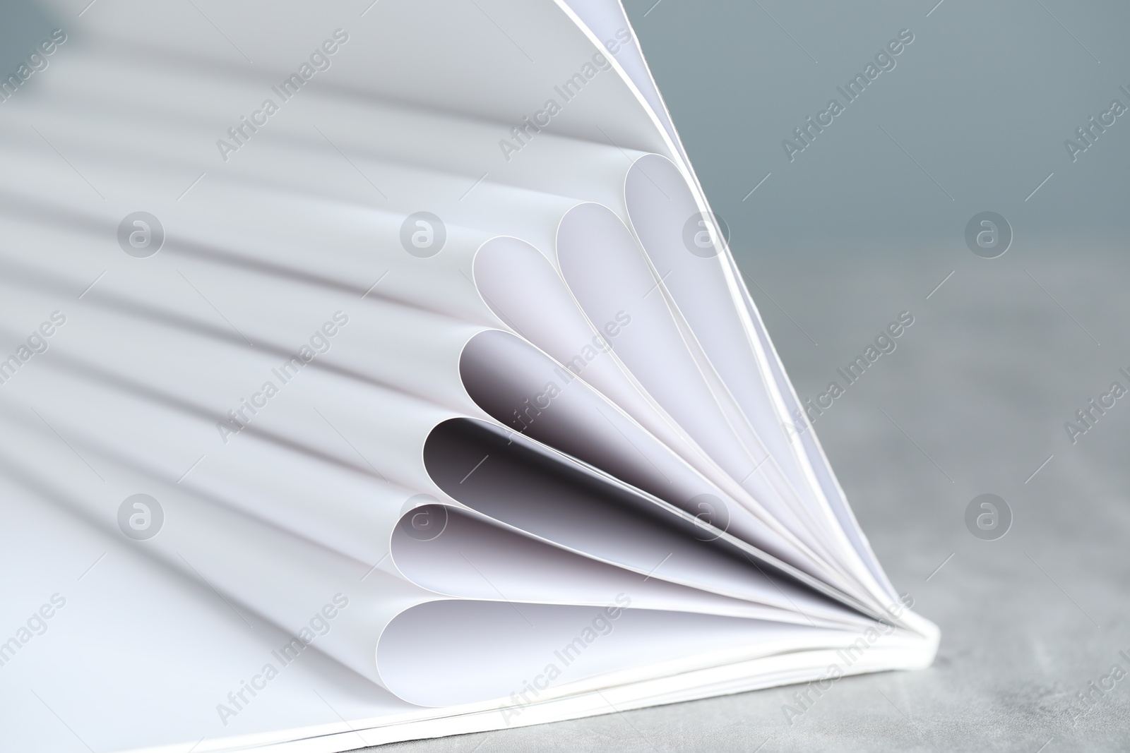 One open magazine on grey table, closeup Photo of One open magazine on grey table, closeup