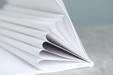 Photo of One open magazine on grey table, closeup