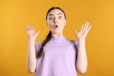 Photo of Portrait of shocked woman on orange background