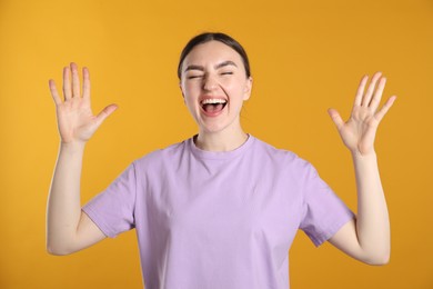 Photo of Portrait of surprised woman on orange background