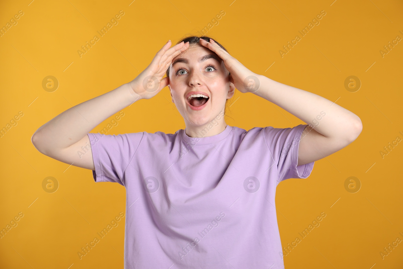 Portrait of surprised woman on orange background Photo of Portrait of surprised woman on orange background