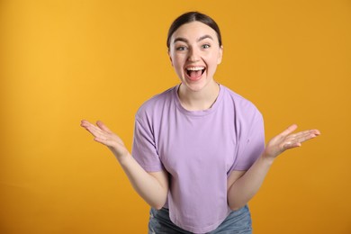 Photo of Portrait of surprised woman on orange background