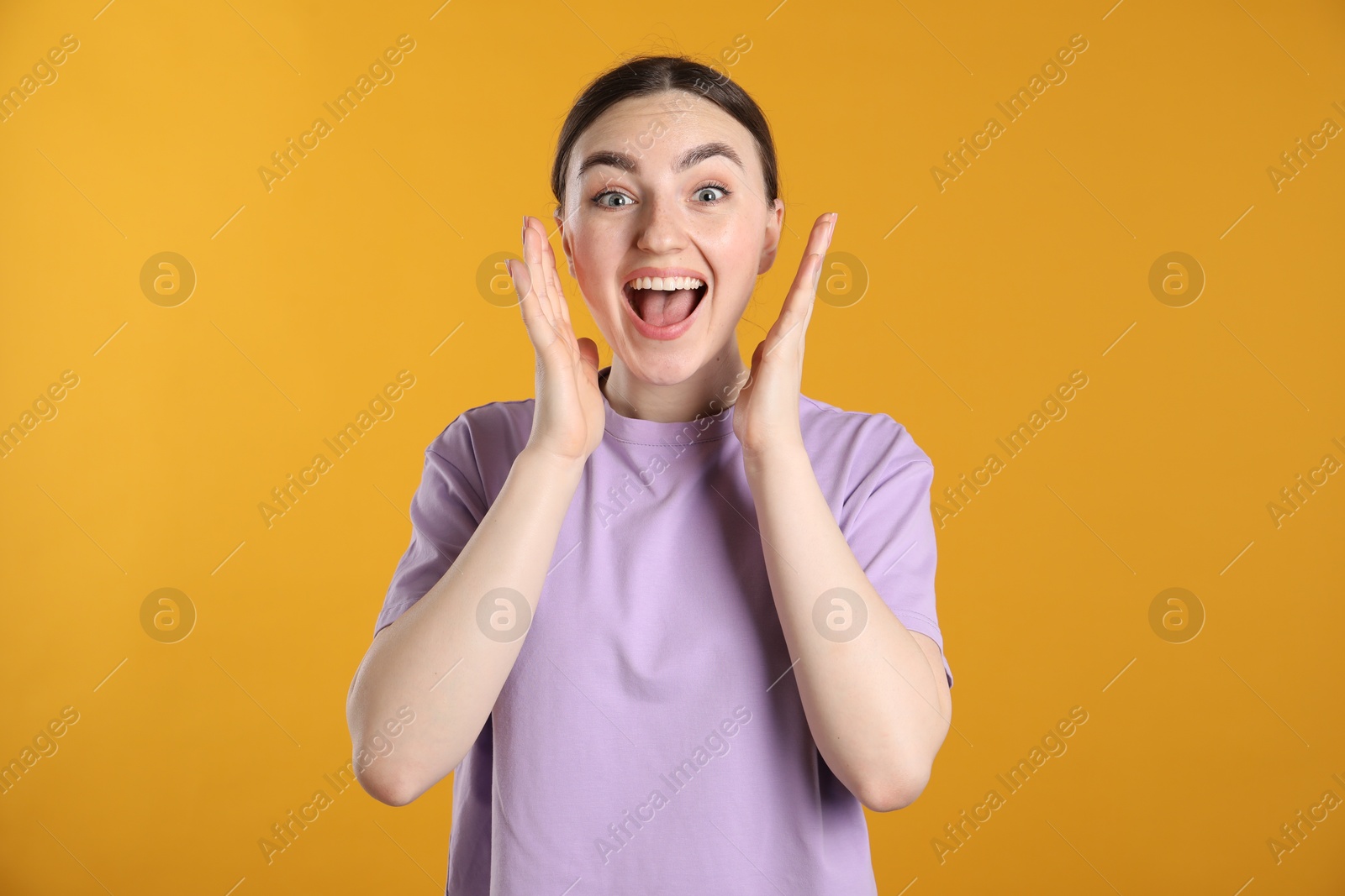 Portrait of surprised woman on orange background Photo of Portrait of surprised woman on orange background