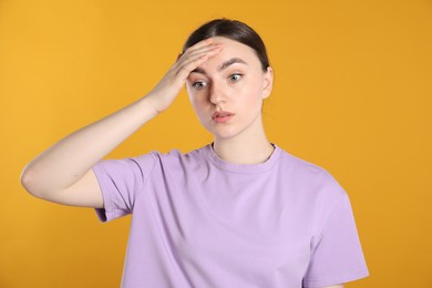 Photo of Portrait of confused woman on orange background