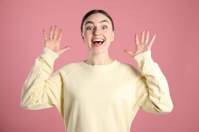 Photo of Portrait of surprised woman on pink background