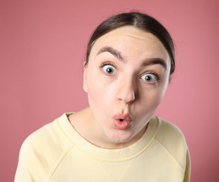 Photo of Portrait of shocked woman on pink background