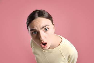 Photo of Portrait of shocked woman on pink background