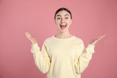 Photo of Portrait of surprised woman on pink background