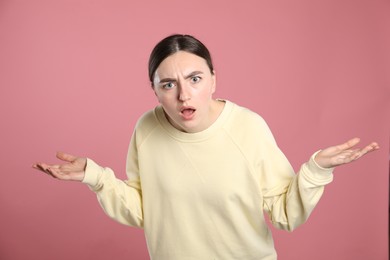 Photo of Portrait of shocked woman on pink background