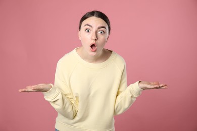 Photo of Portrait of shocked woman on pink background