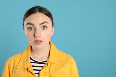 Photo of Portrait of shocked woman on light blue background, space for text
