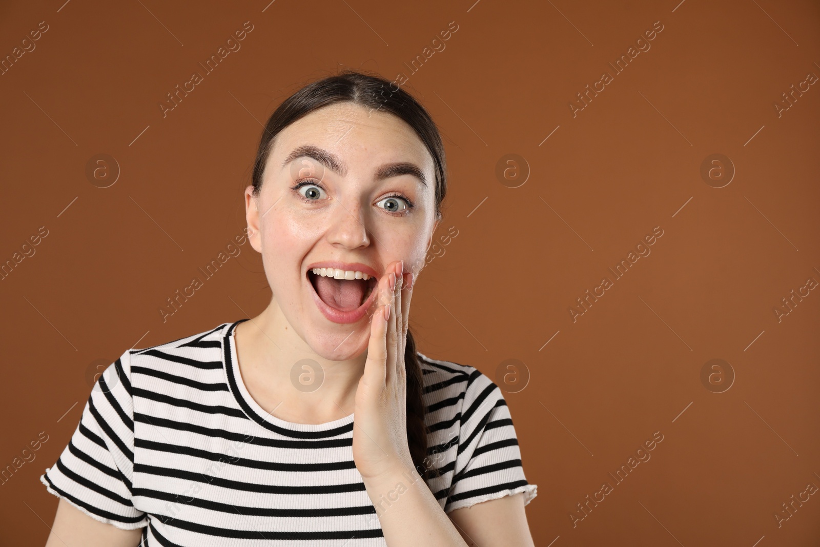 Portrait of surprised woman on brown background, space for text Photo of Portrait of surprised woman on brown background, space for text