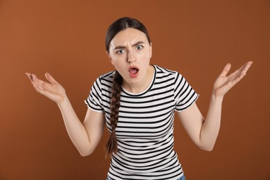Photo of Portrait of surprised woman on brown background