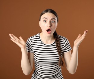 Photo of Portrait of surprised woman on brown background