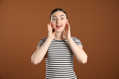 Photo of Portrait of surprised woman on brown background