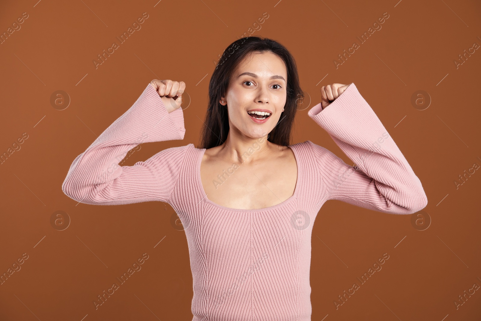 Portrait of surprised woman on brown background Photo of Portrait of surprised woman on brown background