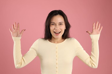 Photo of Portrait of surprised woman on pink background