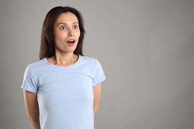 Photo of Portrait of surprised woman on grey background, space for text