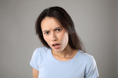 Photo of Portrait of confused woman on grey background