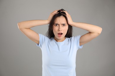 Photo of Portrait of shocked woman on grey background