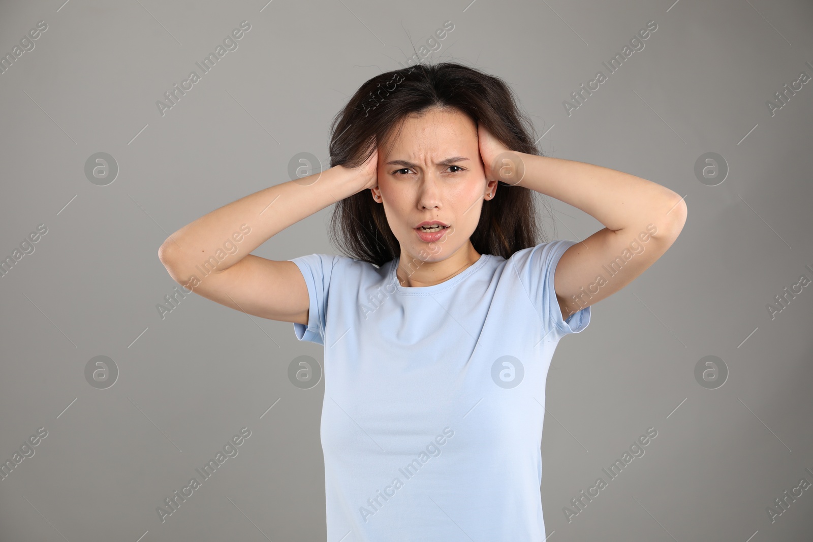 Portrait of shocked woman on grey background Photo of Portrait of shocked woman on grey background