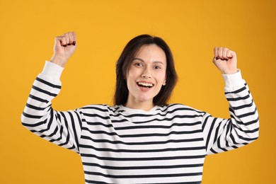 Photo of Portrait of surprised woman on orange background
