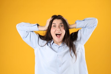 Photo of Portrait of surprised woman on orange background