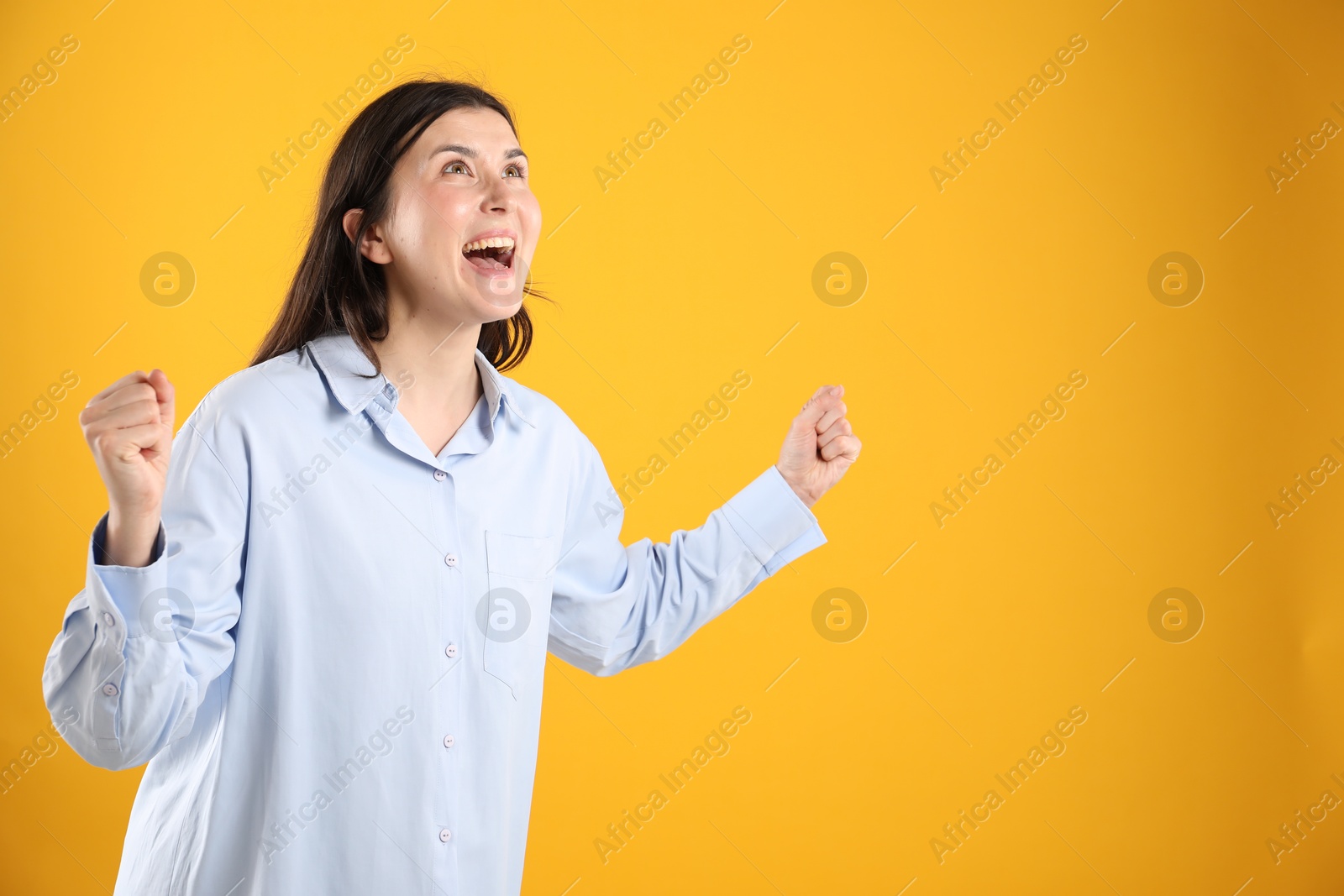 Portrait of surprised woman on orange background, space for text Photo of Portrait of surprised woman on orange background, space for text