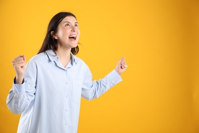 Photo of Portrait of surprised woman on orange background, space for text