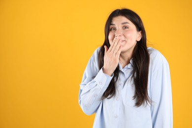 Photo of Portrait of surprised woman on orange background, space for text