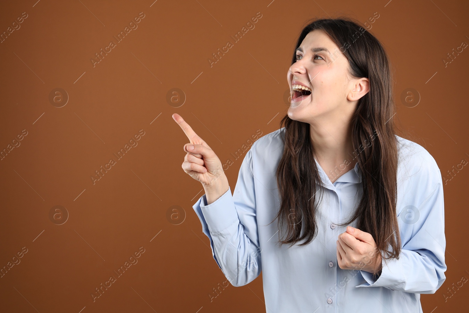 Portrait of surprised woman on brown background, space for text Photo of Portrait of surprised woman on brown background, space for text