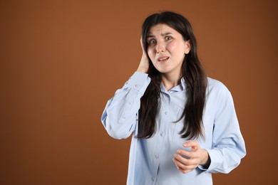 Photo of Portrait of shocked woman on brown background, space for text