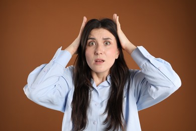 Photo of Portrait of shocked woman on brown background