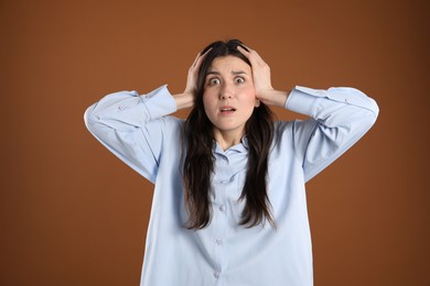 Photo of Portrait of shocked woman on brown background