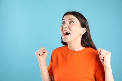 Photo of Portrait of surprised woman on light blue background, space for text