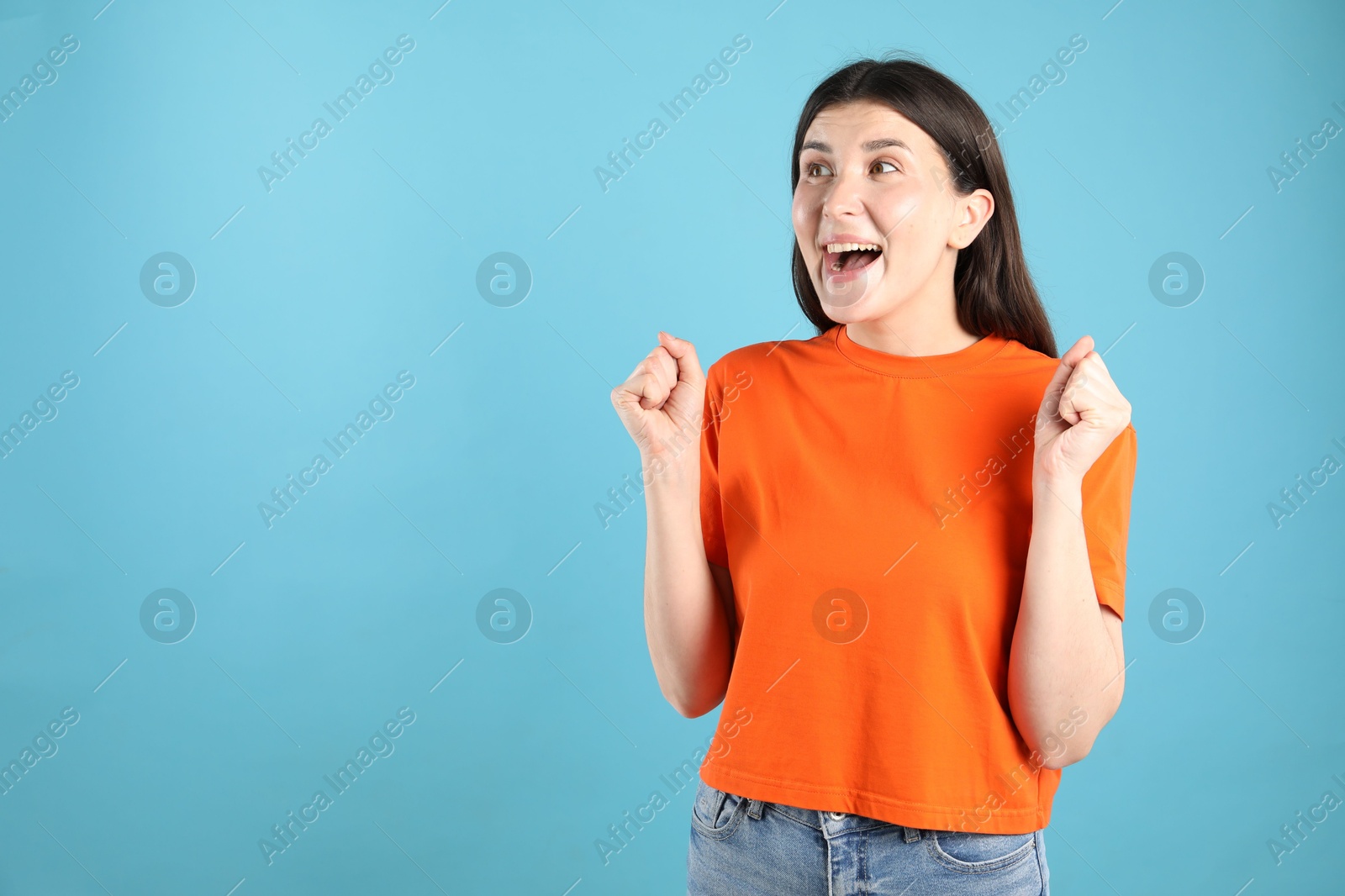 Photo of Portrait of surprised woman on light blue background, space for text