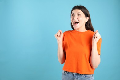 Photo of Portrait of surprised woman on light blue background, space for text