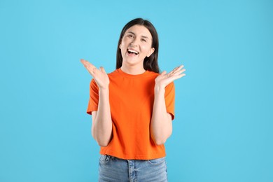 Photo of Portrait of surprised woman on light blue background