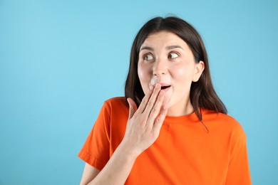 Photo of Portrait of surprised woman on light blue background, space for text