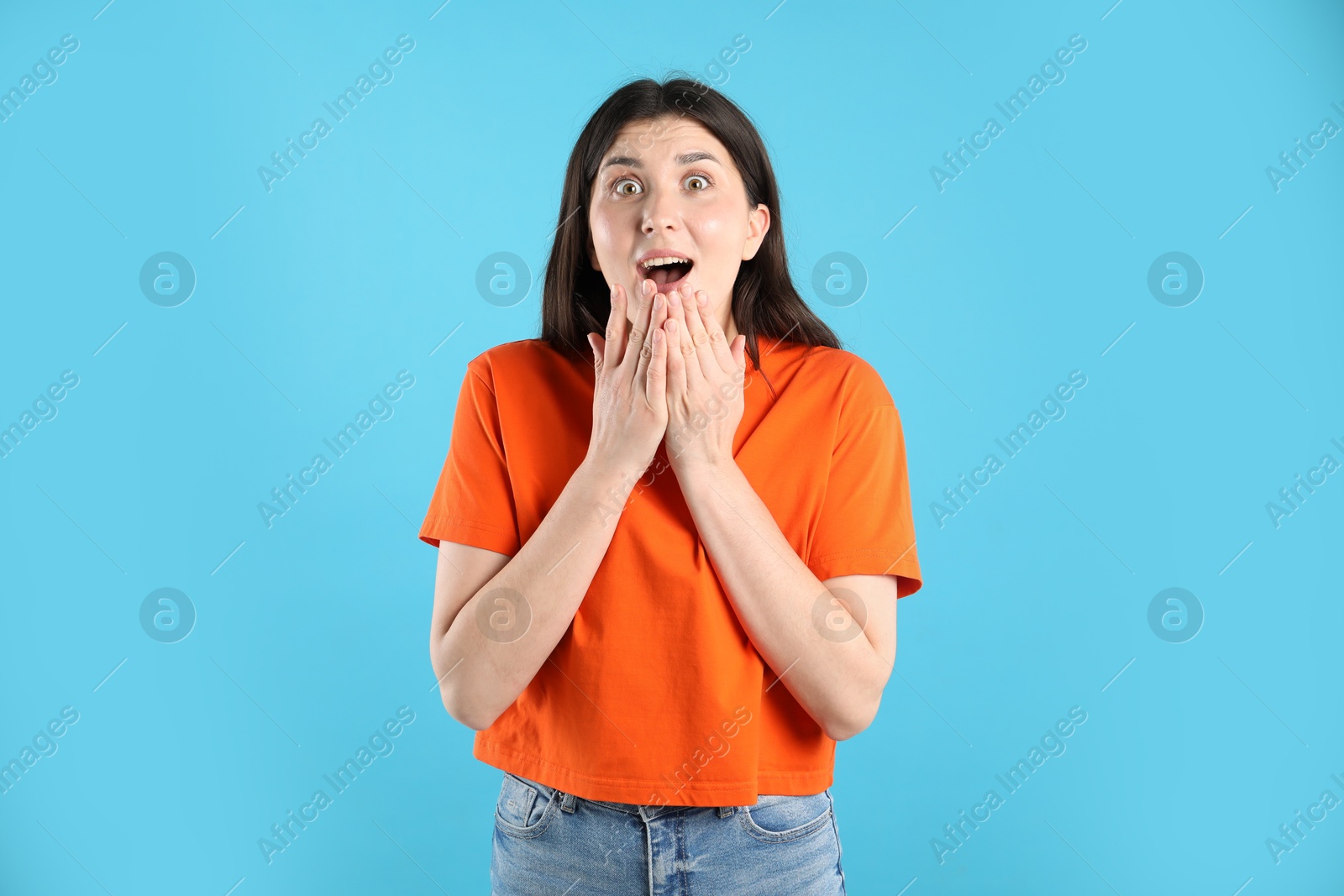 Portrait of surprised woman on light blue background Photo of Portrait of surprised woman on light blue background