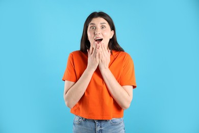 Photo of Portrait of surprised woman on light blue background