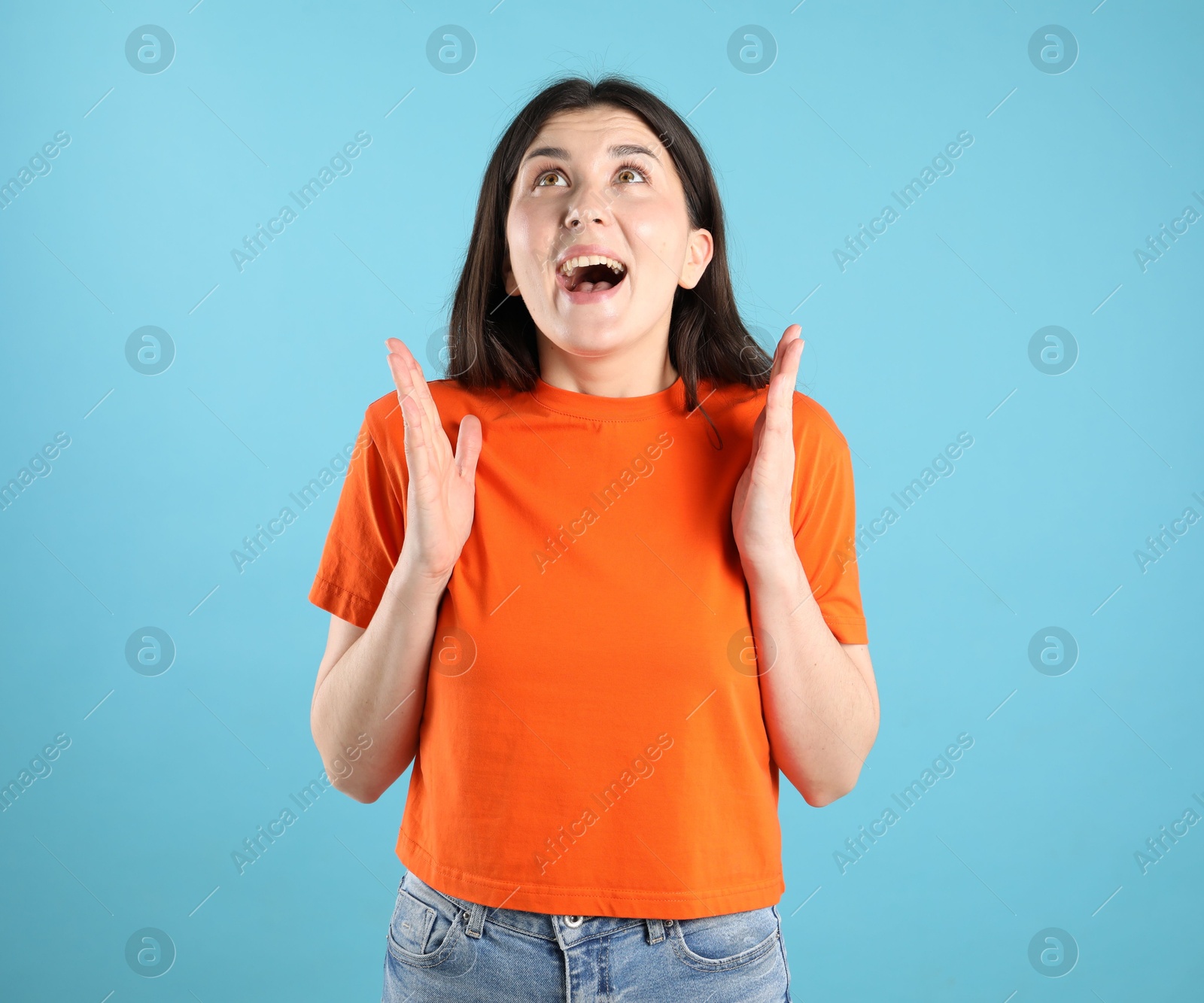 Portrait of surprised woman on light blue background Photo of Portrait of surprised woman on light blue background
