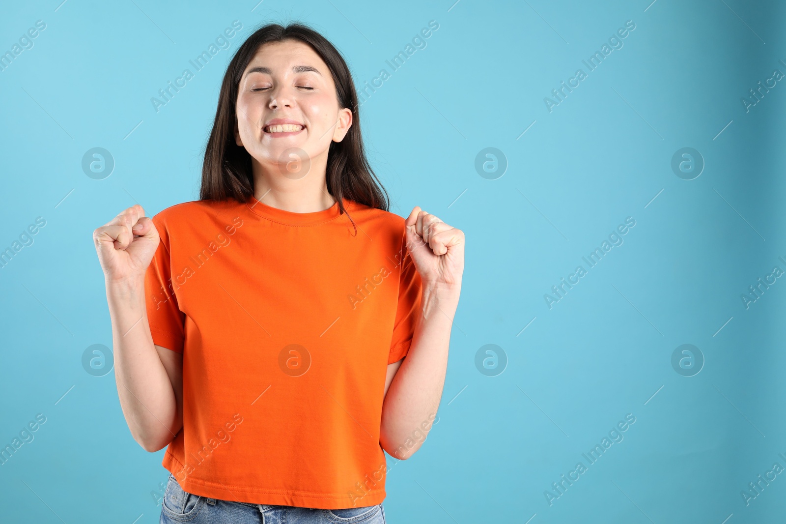 Portrait of surprised woman on light blue background, space for text Photo of Portrait of surprised woman on light blue background, space for text