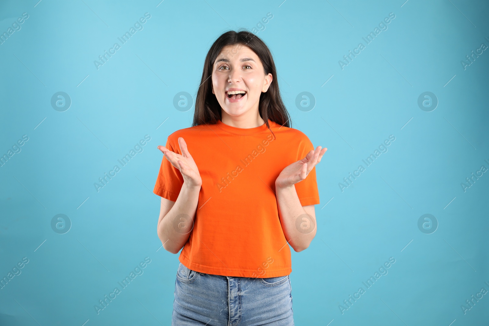 Portrait of surprised woman on light blue background Photo of Portrait of surprised woman on light blue background