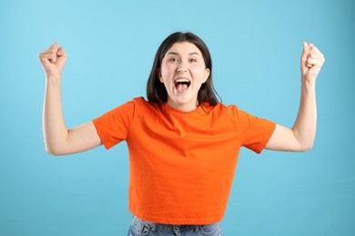 Photo of Portrait of surprised woman on light blue background